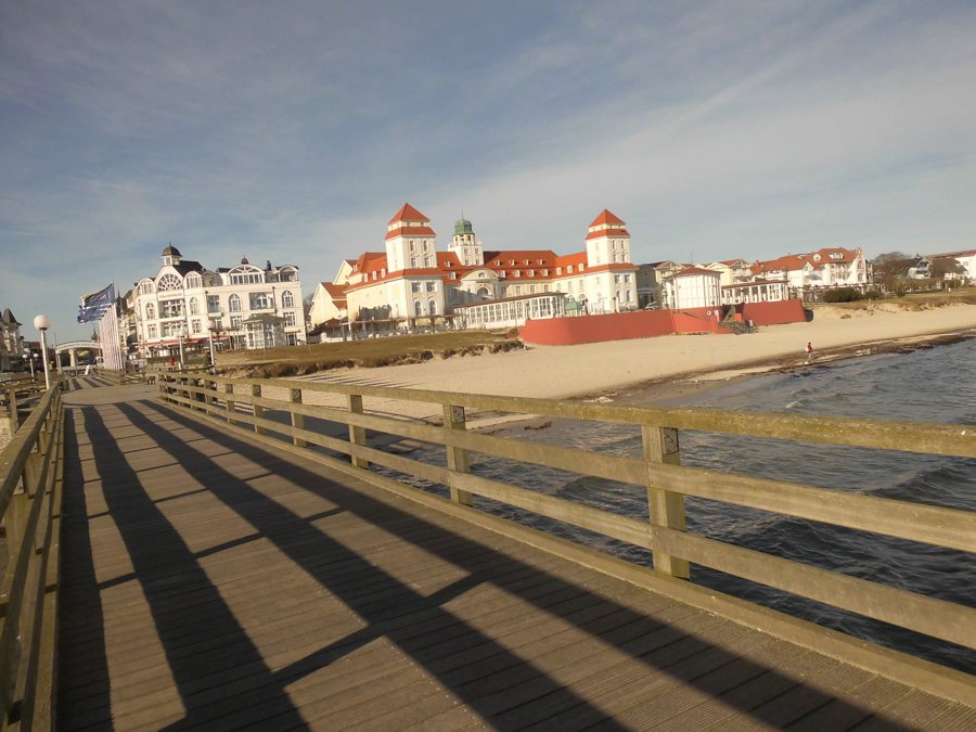Pier leading to a Baltic Sea resort with beach and coastal buildings