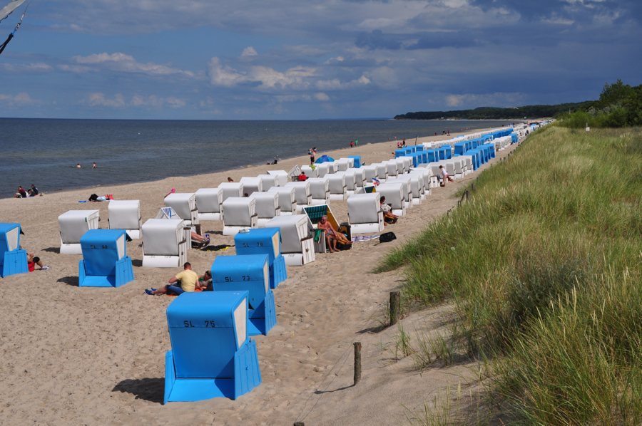 Sandy Baltic Sea beach lined with blue and white beach chairs